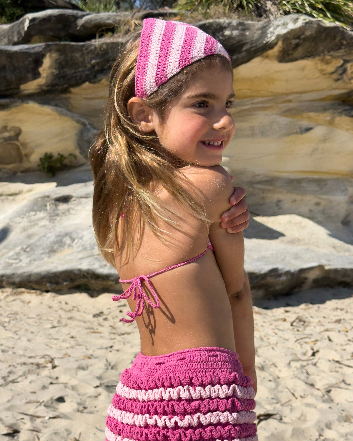 Bambina Ruffle Set in Pink, girls' crochet bikini top and ruffle shorts, back view