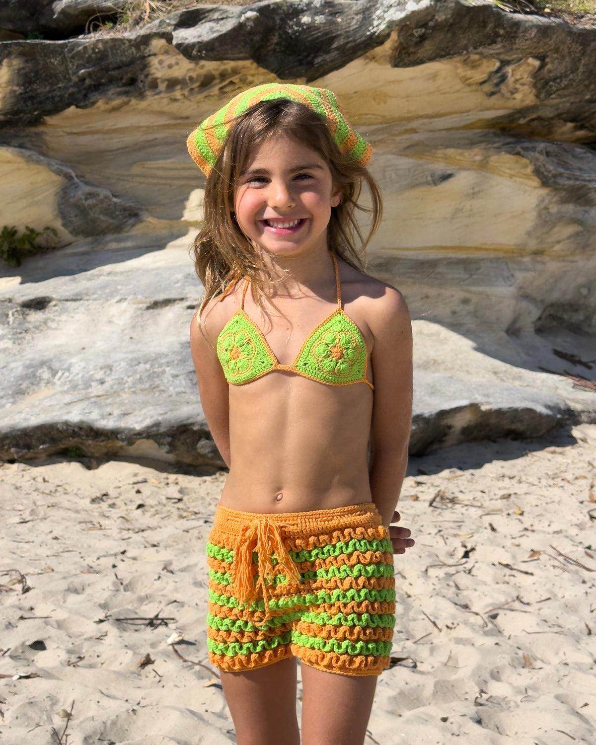 Bambina Ruffle Set in Green & Orange, girls' crochet bikini top and ruffle shorts, front view