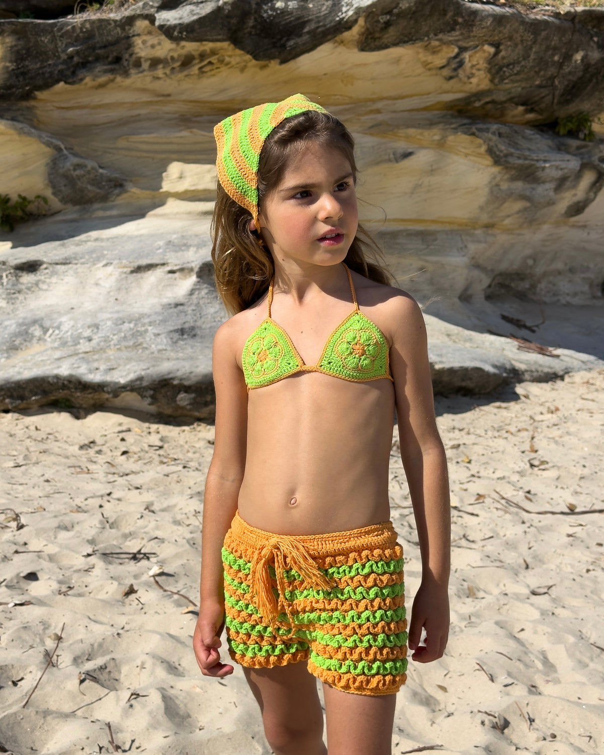 Bambina Ruffle Set in Green & Orange, girls' crochet bikini top and ruffle shorts, side view
